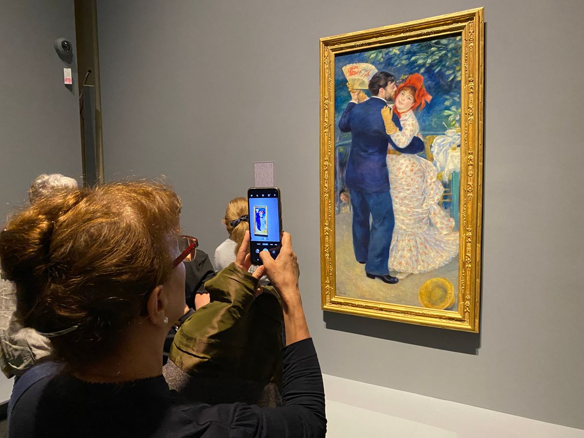 Egy látogató fotózza Renoir a Vidéki tánc című festményét a francia impresszionista mester számos főművét bemutató tárlaton a Szépmûvészeti Múzeumban. Fotó: Arany T. János