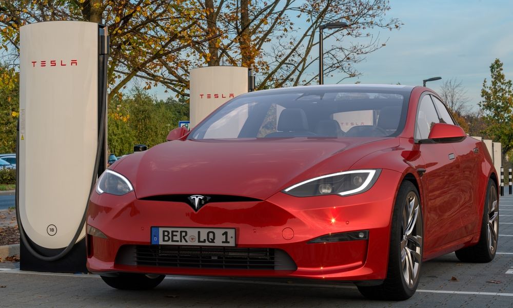 Egy Tesla Model S a töltő mellett.